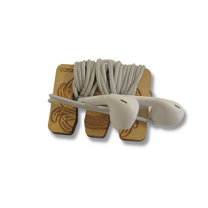 Wooden bag in Crab design, shown with corded earbuds, wrapped for storage or portability.