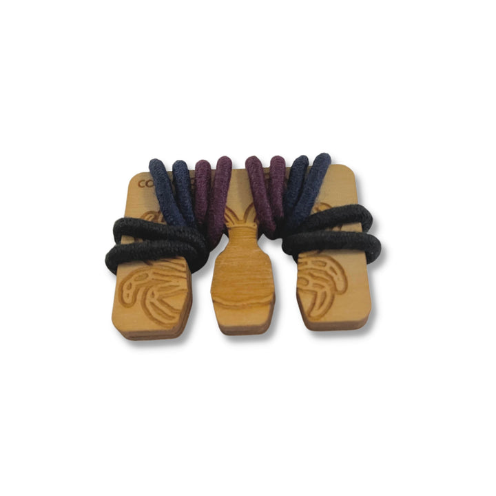 Wooden bag in Crab design, shown with black, blue, and purple hair ties, wrapped for storage or portability.