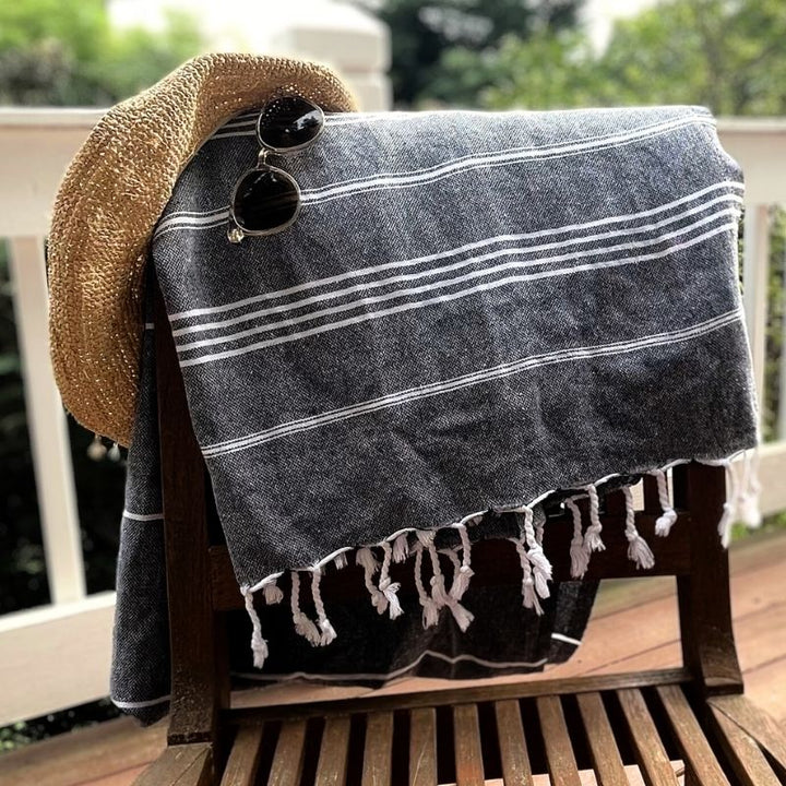 Upcycled Cotton Turkish Towel over wood chair back, shown with hat and sunglasses.