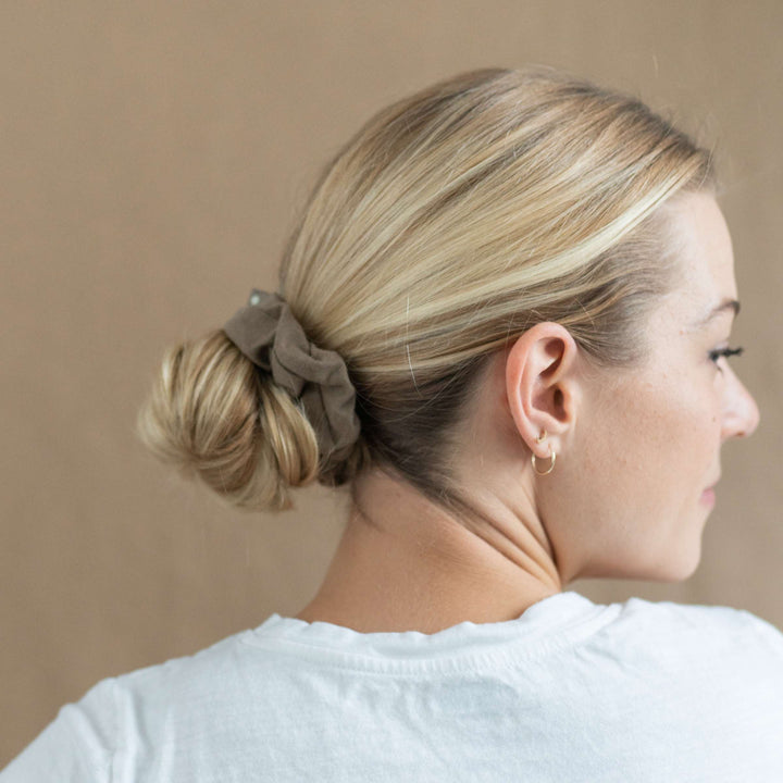 Woman with hair bun, neatly secured with hair scrunchie.