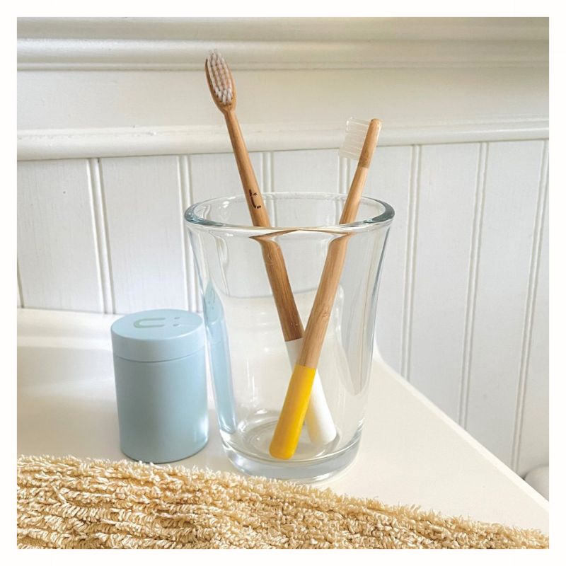 Two Bamboo Toothbrushes, one adult with white handle and one child size with yellow handle.