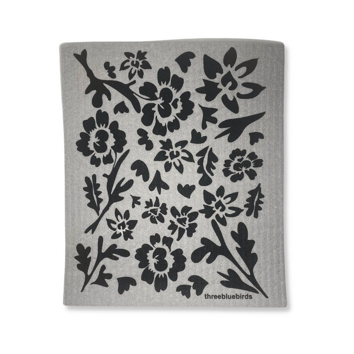 Three Bluebirds Swedish Dishcloth In Black Flora Design on Gray Cloth On White Background.