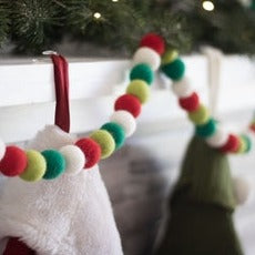 Friendsheep North Pole Eco Garland, in White, Red, Light Green, and Dark Green Colors, Shown on Mantle with Greenery and Stockings.