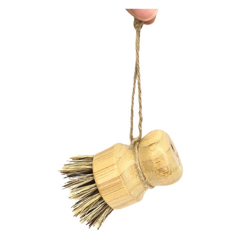 ME Mother Earth Scrub Brush for Pots & Pans, Hanging from Fingers.